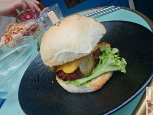 Homemade brioche bun, vegetable steak, tomato, salad, coleslaw, hot sauce and caramelized onions, served with fries.  at Primeur Cantine in Paris