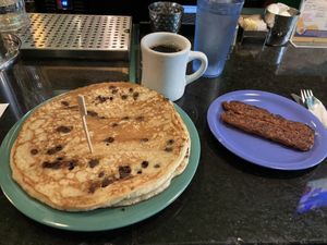 Vegan chocolate chip pancakes with vegan sausage and black coffee    at The Friendly Toast in Boston