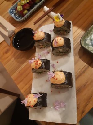 Groene spirulina rijst sushi met avocado, tomaten, zwarte bonen en lente uitjes met chipotle mayo en sesam zaadjes at Hearth  in Amsterdam