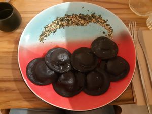 Zwarte charcoal ravioli gevuld met shiitake, teriyaki saus, wasabi crisp en sesam zaadjes at Hearth  in Amsterdam