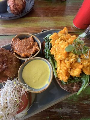 Corn fritter, almond tomato pesto, sweet potato tofu scramble on sourdough with spinach, cashew hollandaise   at Bali Bagus Cafe in Byron Bay