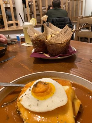Francesinha comes with beautiful herbie fries! The sauce was amazing!!! at Outro Lado in Faro