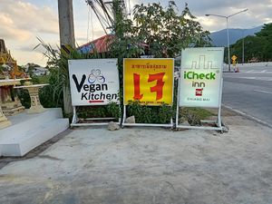 Signs on the highway outside Trams Square Wellness at Ama Vegan Kitchen in Chiang Mai