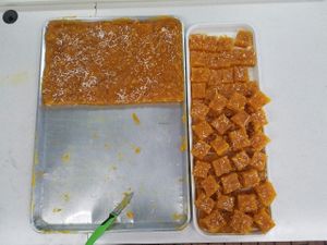Cutting freshly made Bombay Karachi Mango Halwa at Foodland Authentic Indian Cuisine in Corona