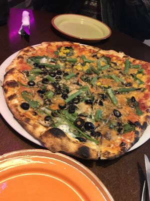 vegan pizza half with corn and the other with olives  at Crustys Pizzeria  in Mallorca