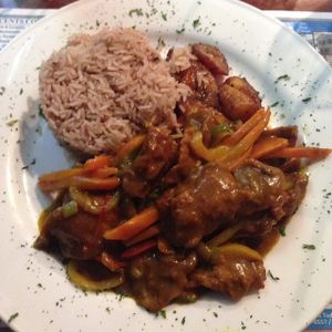 curry ";chicken"; with a side of rice and planting  at Judy's Island Grill in Glen Burnie
