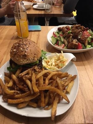 Smokey BBQ mushroom burger, fries and coleslaw. In the bg, chicken strip salad. at Lia's Kitchen in Berlin