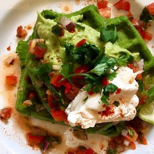 Vegan GF savoury spinach waffles, served w/ a dollop of guac, tofutti cream cheese, pica de gallo salsa and coriander at Exchange Coffee Shop & Kitchen in Bristol