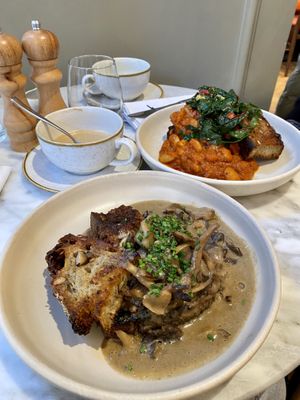Creamy truffle mushrooms on pan-fried garlicky sourdough & Harissa and garlic butterbeans with garlic and chilli sautéed rainbow chard on pan-fried garlicky sourdough.  Amazing.  at Plants by Deliciously Ella in London