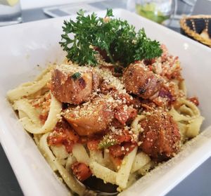Vegan Mediterranean pasta...Fettuccine cooked in a garlic butter with Alfredo sauce, topped with bruschetta, grilled Beyond Meat sausage, and Parmesan cheese. at The Lemon Tree in St Catharines