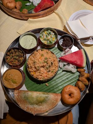 brunch thali (from left to right) :  capsicum curry,  okra fry, coconut chutney,  south Indian style salad,  halwa, assorted pakoras , mint dosa,and in the center vegetable biryani at Copper Bowl in Esslingen