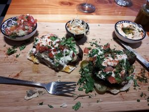 Open pitta board with aubergine, tomato salad, humous, pitta. at Chickpea in Antwerpen