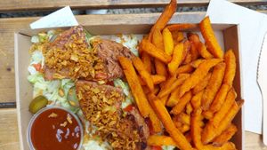 Plate met patty van soja en bonen met zoete aardappelfriet, barbecuesaus, sla en tomaat at Las Vegan's - Kazinczy Trailer in Budapest