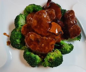 Breaded medallions of wheat protein sauteed in a spicy citrus sauce, over a bed of broccoli. at Ginger Root in New York City