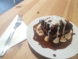 Chocolate and peanut cake with lashings of cream and chocolate sauce! at Holy Cow in Edinburgh
