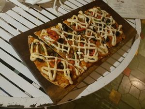 Vegan Pepper, onion, tomato, olives and herbs pizza. Thin, full of toppings and very delicious. 9/10 at The Village Shop in Mumbai