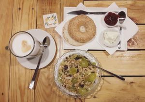Brunch at ITACATE: açai bowl topped with seasonal fruit and made-in-house vegan granola, latte macciato and classic bagel with cream cheese and strawberry jam. at Itacate in Barcelona