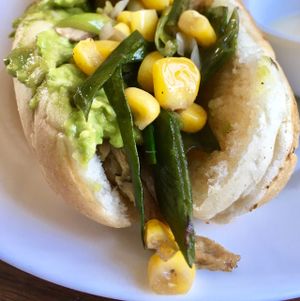 sliced seitan dog with corn, avocado, leeks and onion at Arvoleda in Santiago