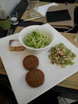 Falafels, raw zucchini spaghetti with pesto, smoked tofu salad, and almond cake at Un'Altra Idea in Bologna