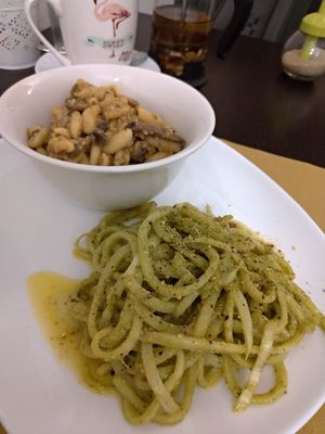 Tempe & mushroom white ragu sauce on fresh pasta / Raw daikon spaghetti in rucola, dried tomato and pistachio pesto at Un'Altra Idea in Bologna