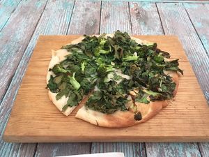 Delicious pizza with spinach, broccoli, and amazing garlic sauce at La Rana Vegana in Cabo San Lucas