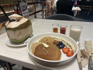 Fresh coconut and fruity pancakes with granola, maple syrup, strawberry sauce and soy milk #Veganuary at Veganerie - Siam Paragon in Bangkok