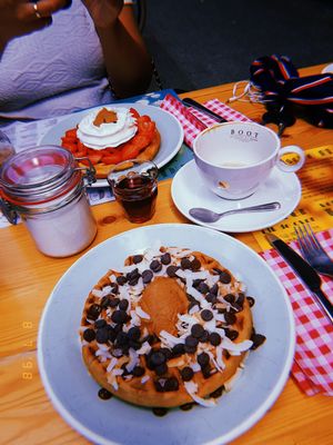 Top one: regular waffle with peanutbutter, strawberrie and whipped cream. Lower one: Vegan waffle with peanutbutter, dark chocolate chips, roasted coconut flakes and maple syrup. at Brunchroom in Amsterdam