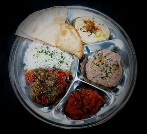 Thali with hummus, vegetable pate, vegan sobrassada, baked vegetables, basmati rice, samosa and pita bread. at Teteria India in Barcelona