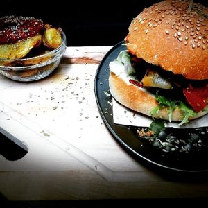 Vegan burger in homemade bread and baked potatoes with brava sauce. at Teteria India in Barcelona