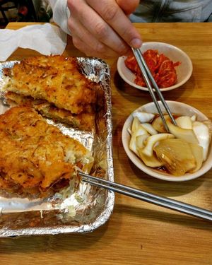 two pancakes with kimchi and soy sauce onions on the side at Soonheene Bindaeddeok - 순희네 빈대떡 in Seoul