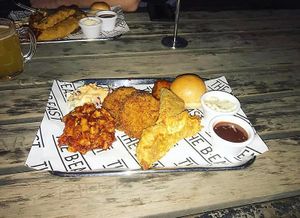 Vegan BBQ Monday Vegan Sampler Tray: chick'n tenders, pickles, sausage, brisket, fried green tomatoes, bread roll, slaw, BBQ sauce and aioli at The b.east in Brunswick East