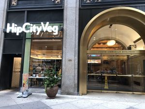 Restaurant store front and the lobby next door with cafe tables inside at HipCityVeg - Broad St in Philadelphia