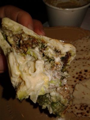 An up-close of the falefal sandwich with pickled turnips, onion, lettuce, think sauce, falafels, hummus, and pita at Saca's Mediterranean Cuisine in Claremont