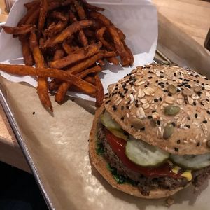 Impossible burger vegan style, add pickles, ketchup, and mustard on wheat bun with sweet potato fries  at Hopdoddy Burger Bar in San Antonio