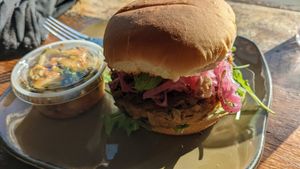 Homemade burger with spicy cucumber side at NU Kitchen in Somerville