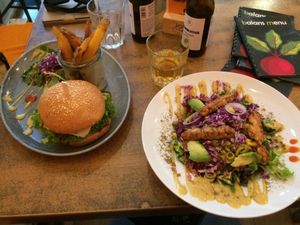 Salad with tempeh and avocado on the right, burger with chickpea patty on the left  at Balans Bistro in Bratislava