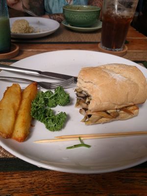 Half-eaten fried mushroom, onion and garlic sandwich with crispy farm potatoes! Soooooo good! at Reform Kafe in Chiang Mai