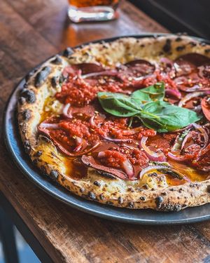 Queen Bee: salami, red onion, fresh basil and mozzarella with a drizzle of hot honey and Napoli sauce at Red Sparrow Pizza in Collingwood