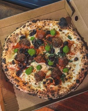 Special pizza topped with meatballs, olives, basil and mozzarella with a drizzle of Napoli sauce and pesto at Red Sparrow Pizza in Collingwood
