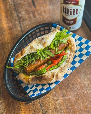 Sausage sizzle pizza sanga with pesto, mozzarella, rocket and roasted red capsicum at Red Sparrow Pizza in Collingwood