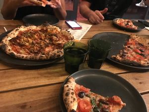 On the left: (special) burger meat, bacon, onion rings, pickles and BBQ 
On the right and middle bottom the puttanesca  at Red Sparrow Pizza in Collingwood