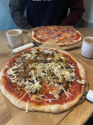 Vegan pizza with mushrooms, and another one with vegan bacon  at Casa La Familia in Vilnius