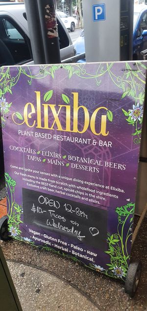 Restaurant  sign on footpath adjacent mall at Elixiba in Byron Bay
