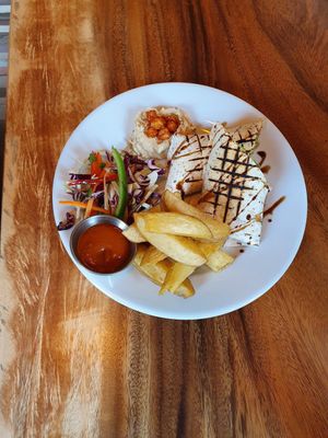 Smokey tempeh wrap with chips and slaw at Dandelion Cafe in Saltaire