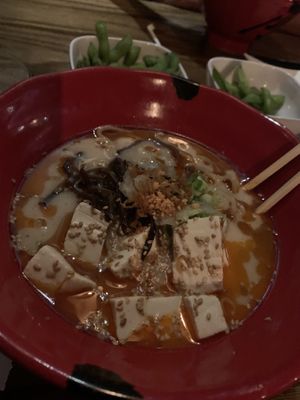 Spicy creamy vegan ramen with some edamame in the background.  at JINYA Ramen Bar in Las Vegas