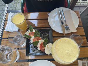 Caprese salad, fresh orange juice and mango lassi  at Organi Chiado in Lisbon