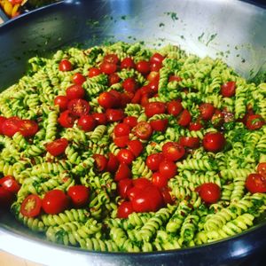 Arugula & basil pesto pasta salad topped with grape tomatoes. at Chic Peas Veg in Toronto