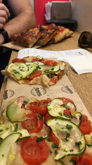 Vegan pizza in the front at Romana Pizza in Lisbon