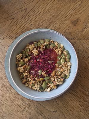 Porridge with homemade rhubarb compote and rose, topped with pistachios, homemade granola and pumpkin seeds at Brochan in Edinburgh