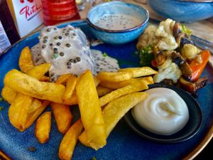 Steak seitan pepersaus met frieten, veganaise en warme groenten at Le Touquet in Oostende